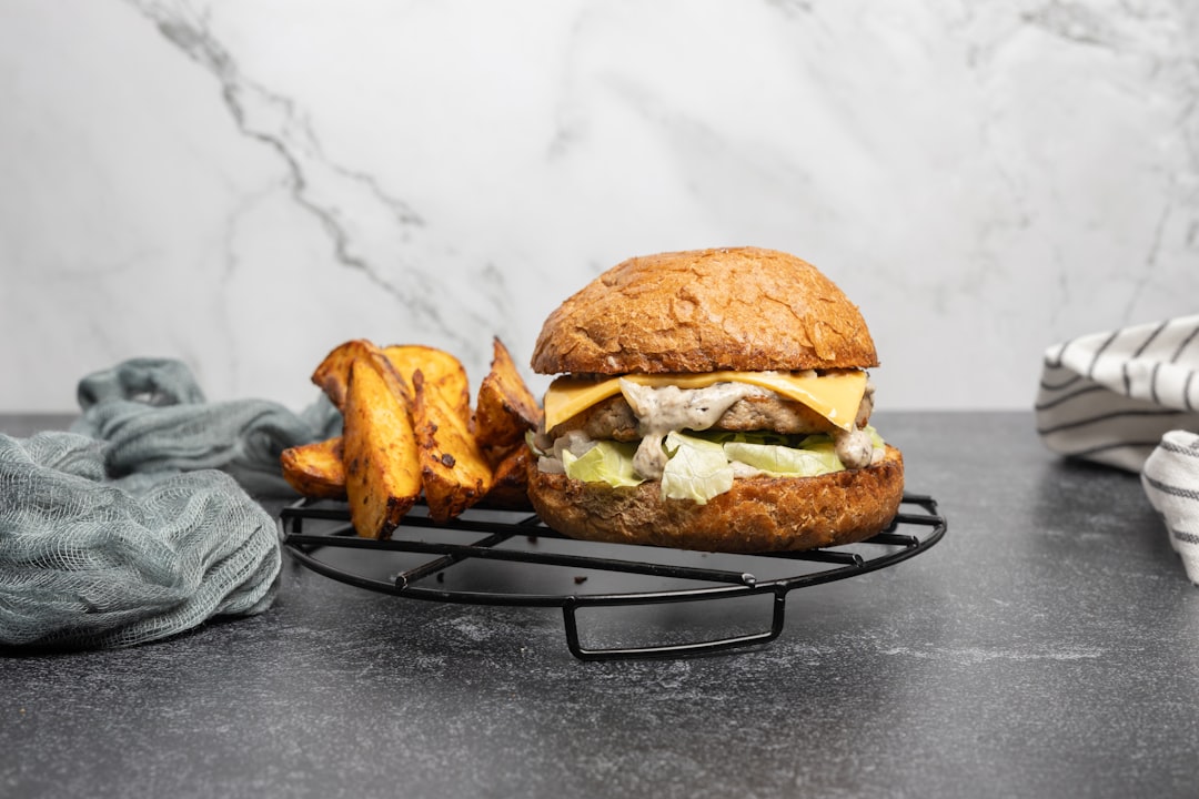 a-burger-with-a-side-of-fries-on-a-cooling-rack-ia6zbosly1i